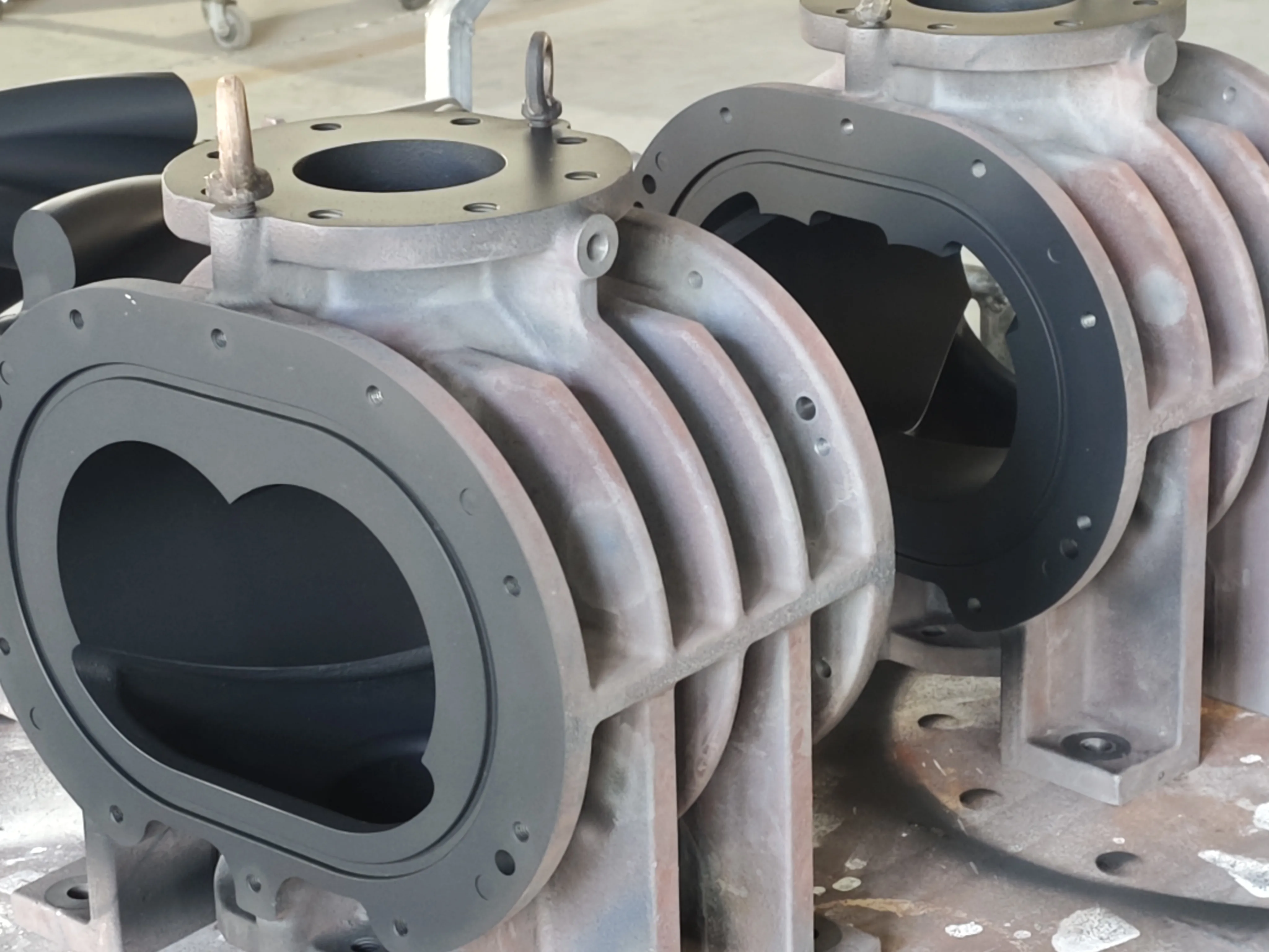 Machined vacuum pump housings and casing components with bore openings, flanges, and bolt patterns