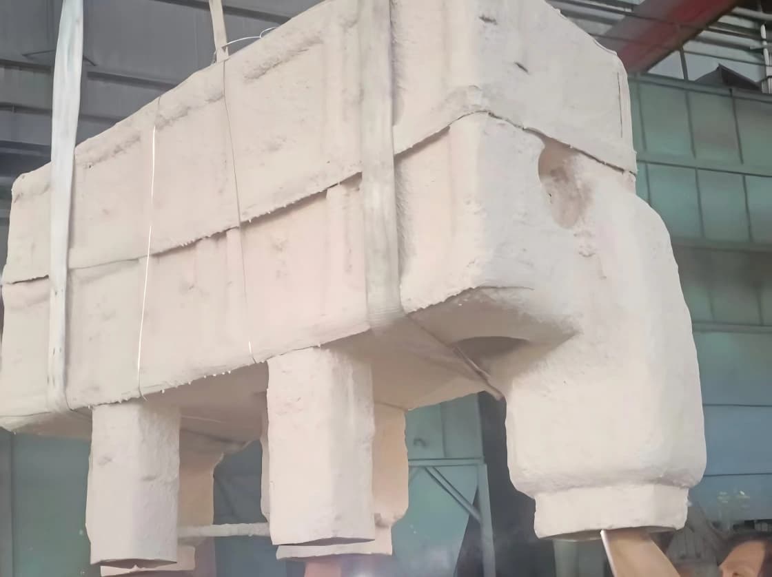 Refractory shell formed around the foam pattern, then fired at 1000 °C — the foam burns out and the shell is ready for the iron or steel pour
